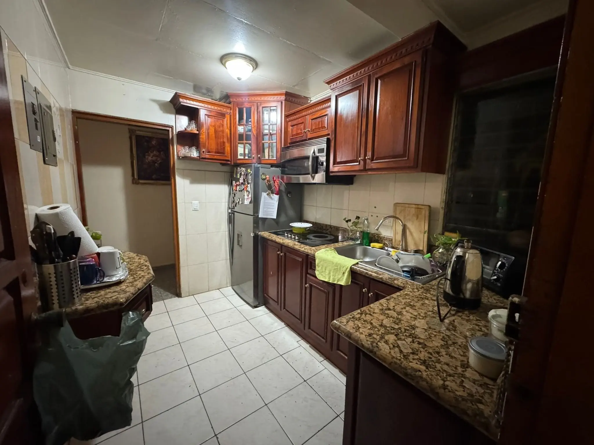 Foto hecha con móvil de una cocina de inmueble con poca luz y presentación poco cuidada